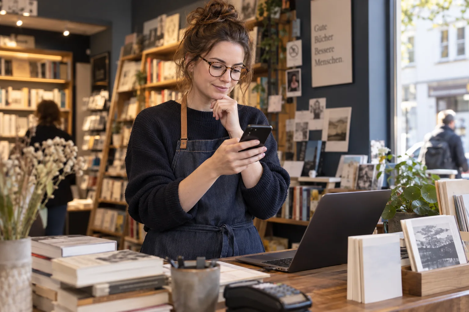 bunq vs. Kontist: Geschäftskonten im direkten Vergleich Buchhändlerin prüft Kontofunktionen auf dem Smartphone