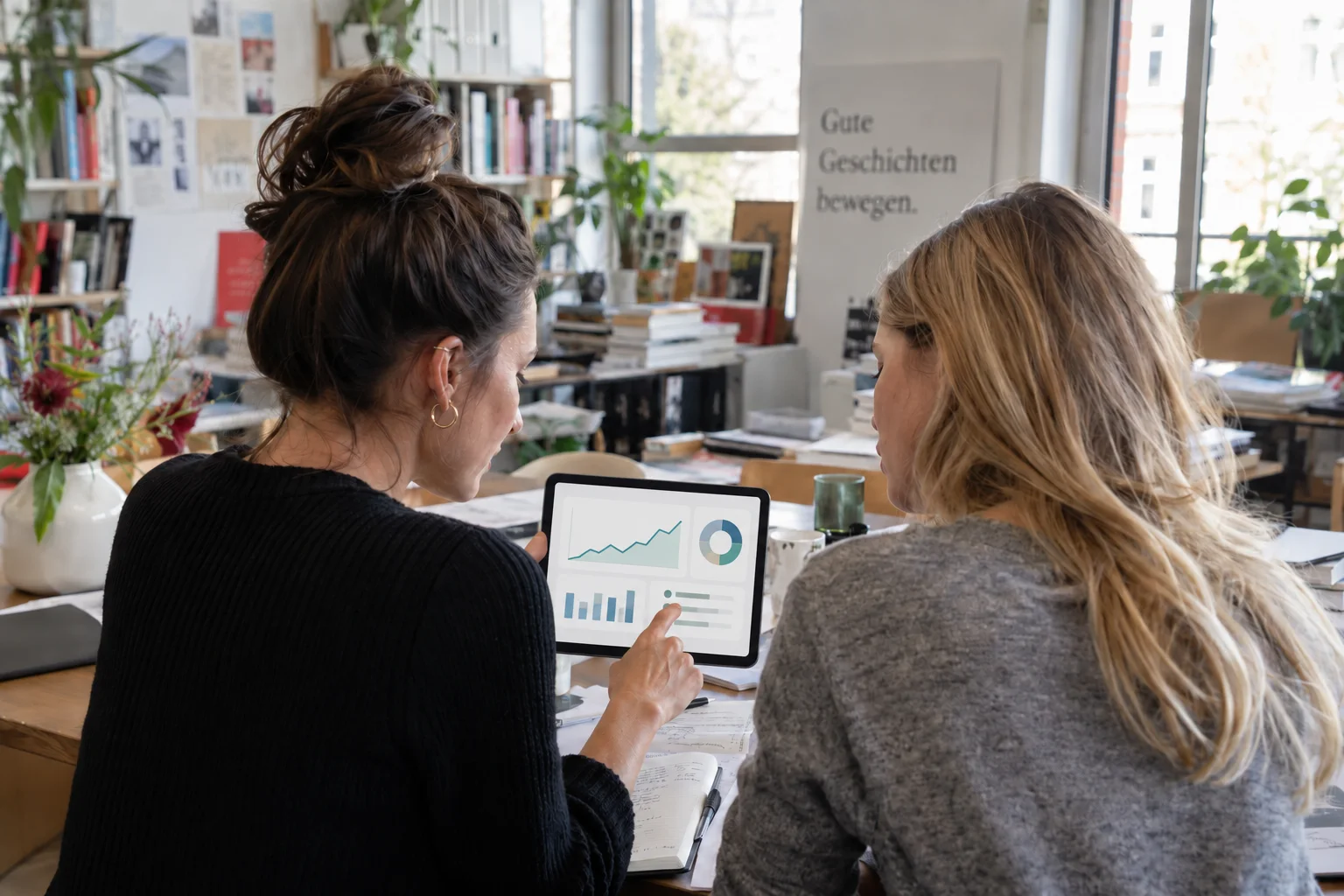 Verlegerinnen prüfen Geschäftskonten gemeinsam am Tablet