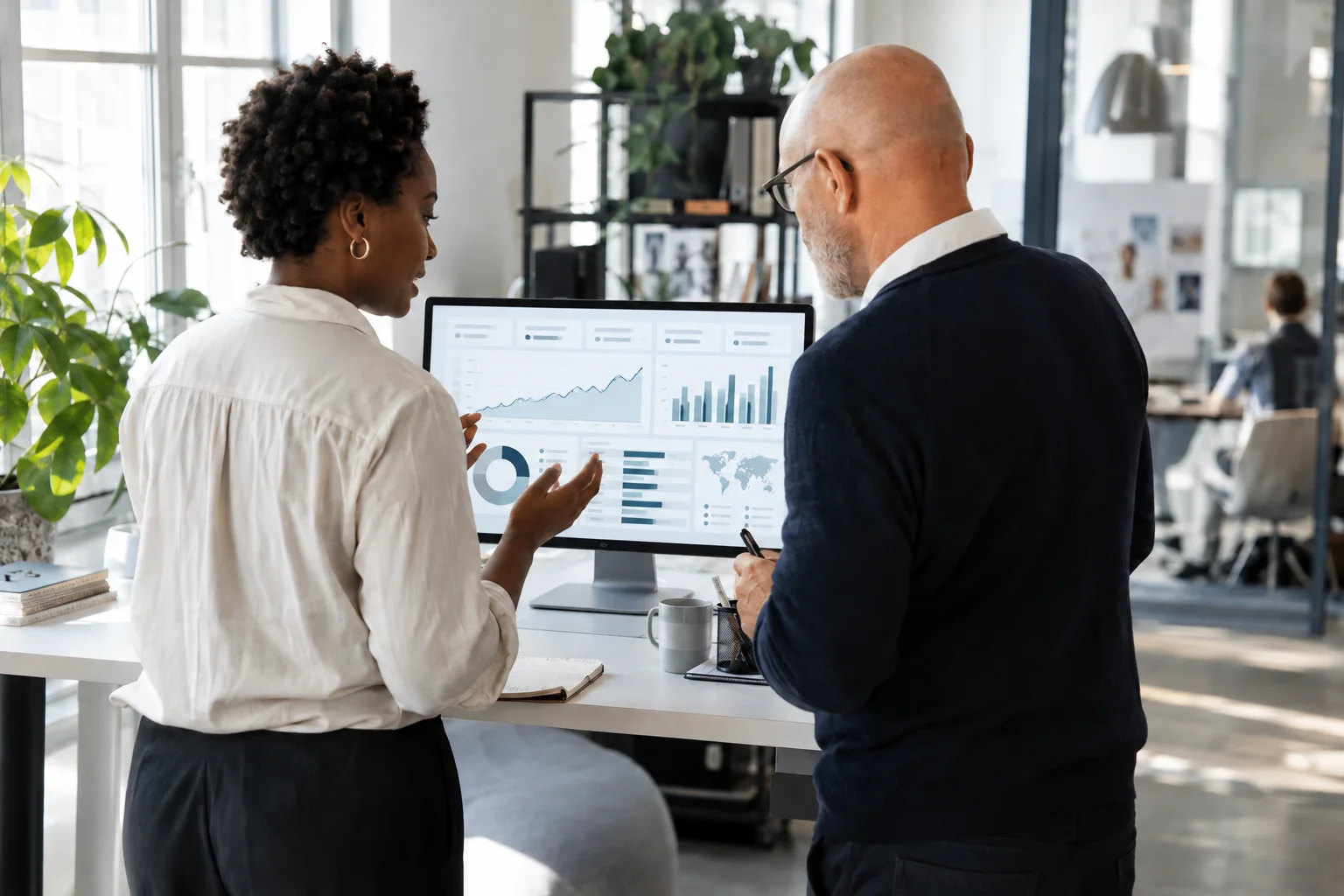 Kontist vs. FYRST vs. Qonto: Geschäftskonten im direkten Vergleich Zwei Geschäftspartner vergleichen digitale Kontofunktionen am Bildschirm